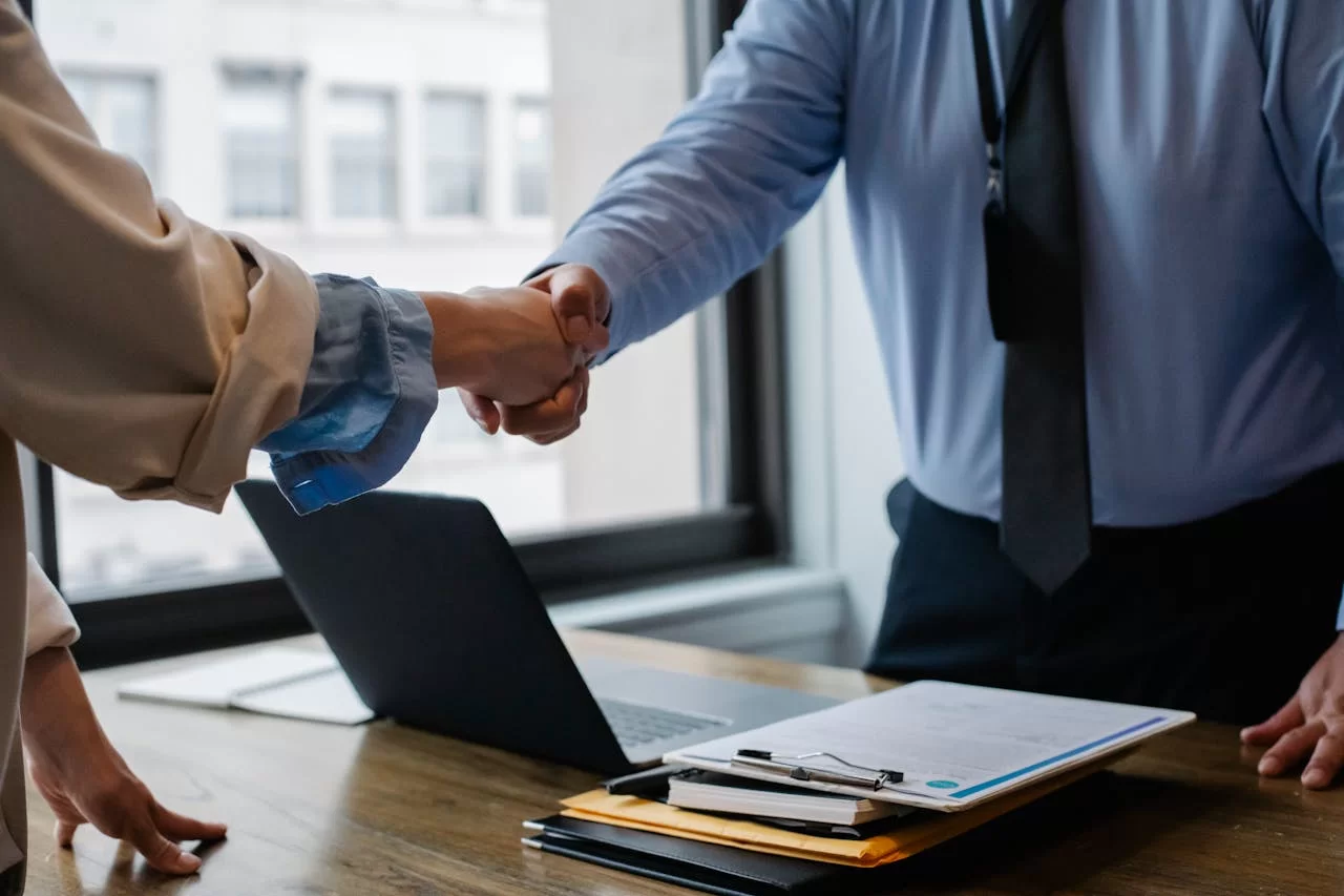 2 people shaking hands in an office